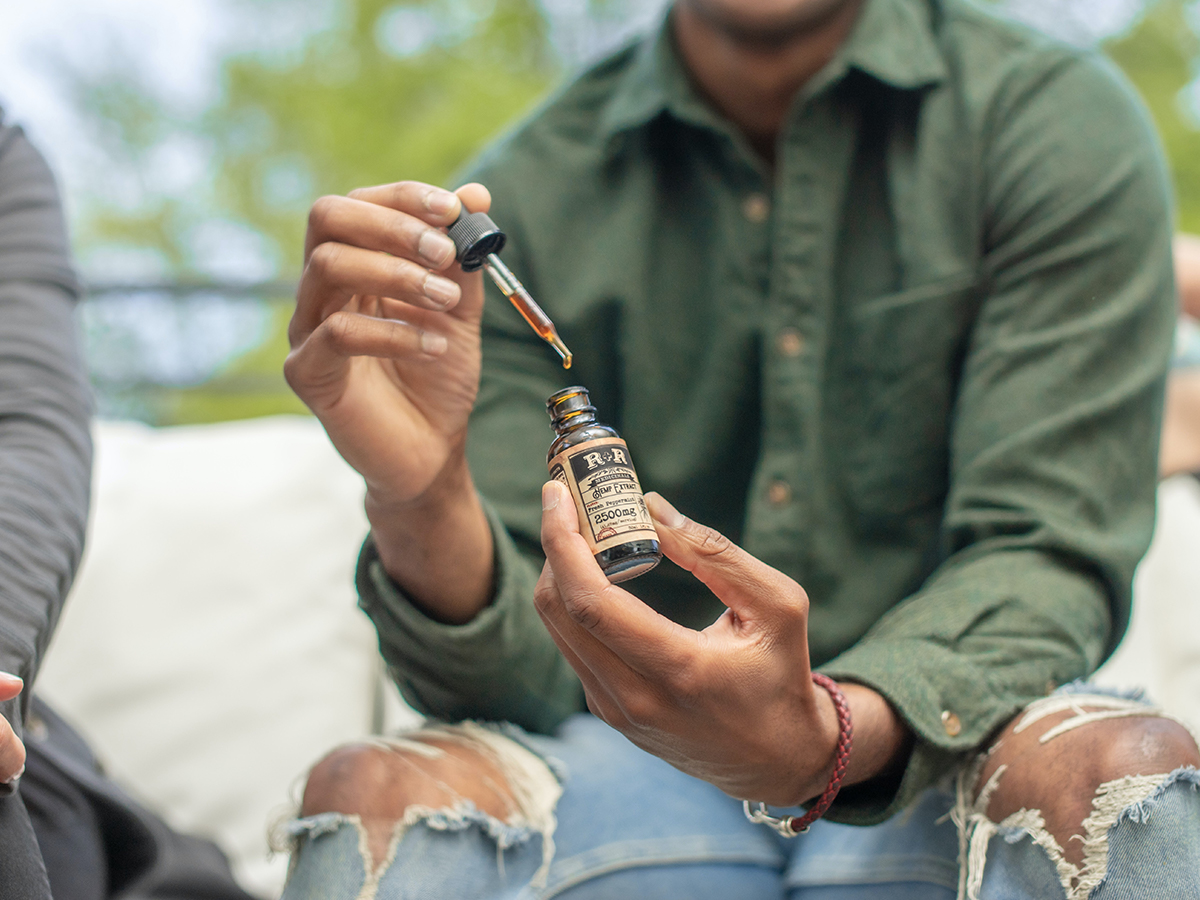 Person Holding Open CBD Bottle