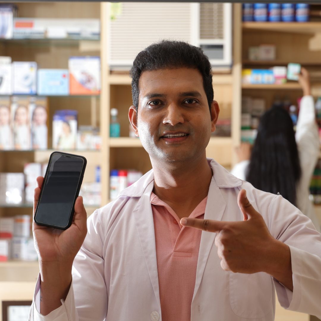 Pharmacist holding up a mobile phone